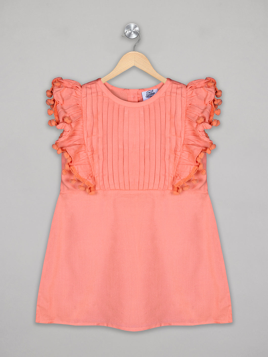 Solid orange knee length dress for girls with pom pom detailing
