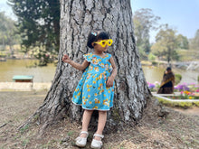 Load image into Gallery viewer, Model wearing blue floral knee length sleeveless frock for girls 
